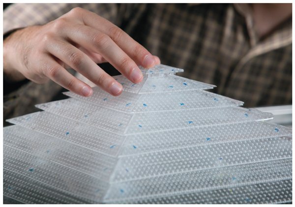 The purpose of this acoustic cloaking device is to return sound waves to a listener as if nothing were there to alter them. The researchers performed a long series of calculations to determine the precise placement of the holes and plastic sheets that would alter the reflected waves’ trajectories to match those from a flat surface. The technology could potentially be used for underwater sonar cloaking, or to adjust acoustics in concert halls. <strong>Photograph courtesy of Pratt School of Engineering, Duke University.</strong>