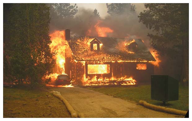 Homes often burn because of flying embers from a fire that is not necessarily nearby. In the absence of wood shingle roofs, vulnerable vents that allow embers into the attic above or crawlspace below a house cause many ignitions. For several homes lost during the 2007 Angora Fire near South Lake Tahoe, California, such as the one shown above, adjacent vegetation was not the culprit. <strong>Image courtesy of the U.S. Forest Service Lake Tahoe Basin Management Unit.</strong>