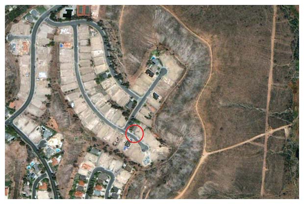 Few homes survived the 2003 Cedar Fire as it ravaged the San Diego, California, community of Scripps Ranch, shown here after the fire. One of the remaining homes (<em>circled</em>) had just had its wooden roof replaced with a fire-resistant one, against the wishes of the local homeowner’s association. Studies have shown that structures with wooden roofs can be up to 20 times more likely to be destroyed in a wildfire, depending on their distance from flammable vegetation. <strong>Image courtesy of Richard Halsey.</strong>