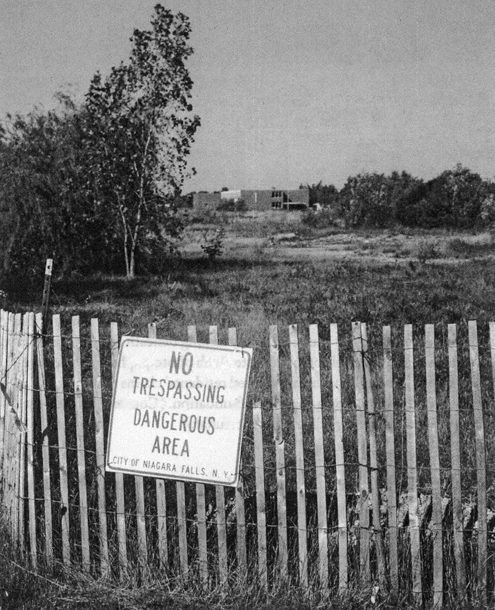 Located behind a warning-bedecked fence by the time this 1978 photo was taken, the 99th Street School had opened in 1955. It represented a second construction attempt, positioned 30 yards north of the original site. The rebuild occurred after the original school’s foundation sank into a chemical pit. From <em>Love Canal</em>. Credit: Penelope Ploughman, August 1978/SUNY, Buffalo